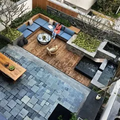 A multi-level terrace designed for versatile outdoor living. This concept demonstrates intelligent space planning, with a raised wooden deck for lounging, a lower stone patio for dining, and cascading water features that add movement and tranquility to the urban environment.