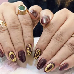 When your nails say luxury before you do. This stunning set features a deep burgundy base with intricate, textured gold foil leaf patterns.
