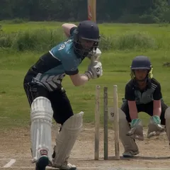 A classic action shot of the bat meeting the ball. This player is executing a perfect defensive block.