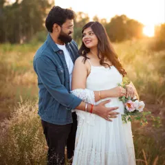 A sweet moment shared between the expecting couple. The soft sunlight and natural background make this a warm and genuine portrait of their journey together.