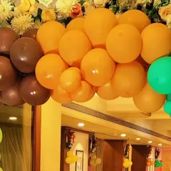 A close-up view of a balloon arch with a unique color combination of brown, orange, and green. This type of organic color palette can be used for jungle-themed parties or rustic-themed events.