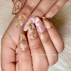 For the bold and celestial soul, this set features 3D sculpted golden snakes and starbursts on a soft, marbled nude base. I love creating these high-end, statement nails that are pure magic.