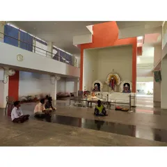 The main prayer hall of the Sai Temple, where devotees can sit in quiet contemplation. The double-height space is naturally lit from above, creating a serene and focused atmosphere.