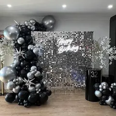 This black and silver theme is the definition of glam. A silver sequin wall, a neon sign, and a dramatic balloon arch with starburst accents create a high-end, celebratory look.