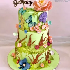 This three-tiered floral wonderland cake was designed for a nature-themed birthday. It features hand-sculpted sugar flowers, delicate butterflies, and edible moss textures for an enchanting look.