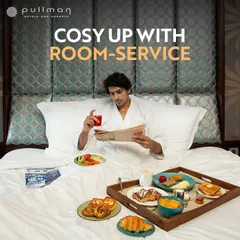 Cozy up with room service at Pullman. This image of a guest enjoying an elaborate breakfast in bed shows the luxurious and comfortable staycation experience I offer.