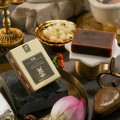 A close-up composition for Zeva's 'Nak' bath soap. We used contrasting textures of smooth stone, delicate lotus petals, and ornate brass to create a visually interesting and culturally rich setting for the product.