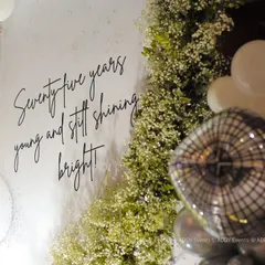 Personalized backdrops tell a story. For this 75th birthday, we included a custom sign with the message "Seventy-five years young and still shining bright," adding a heartfelt and personal touch to the glamorous photo corner.