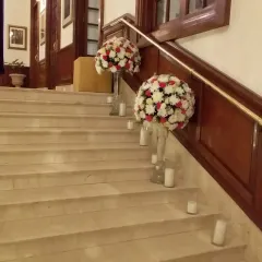 An elegant staircase decoration. I placed large floral bouquets on glass stands and surrounded them with candles to create a warm and inviting path.