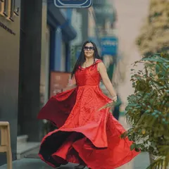 Capturing the perfect twirl for a fashion influencer's post. The movement in the red dress creates a vibrant, eye-catching image that stops the scroll, set against a blurred street scene to emphasize the subject.