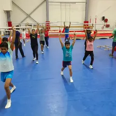 A group of young gymnasts practicing overhead lunges. These foundational exercises build stability, coordination, and strength, which are crucial for long-term athletic development.