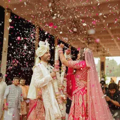 A magical varmala moment, with the bride placing the garland on the groom under a shower of confetti and flower petals.