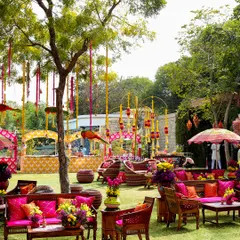 The seating area at the "Raangon ka Jashn" carnival, filled with bright pink and orange cushions, traditional wooden furniture, and hanging floral decor. The entire space was a celebration of color.