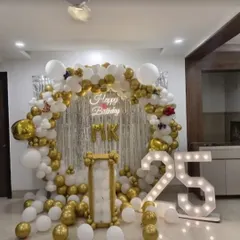 This elegant white and gold balloon backdrop is customized for a 25th anniversary celebration. The large light-up "25" marquee numbers serve as a brilliant photo prop and a central element of the decor.