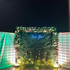 A lush green photo wall with a "Thank You" neon sign, created for a corporate appreciation event at Le Méridien, Gurgaon.