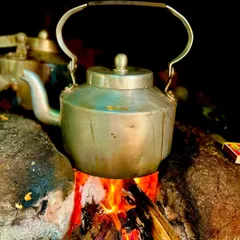 Even a simple cup of tea is given the traditional treatment. An aluminum kettle sits on a wood fire, showcasing our commitment to authentic preparation methods in every detail.