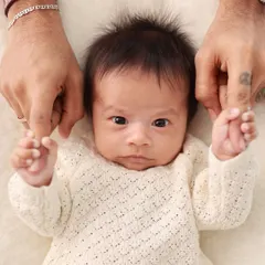 A newborn holds onto their dad's fingers. These are the details that truly matter, showcasing the strength and delicacy of this new connection.