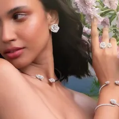 A beauty-focused shot for Renu Oberoi's 'La Vie En Rose' collection, where the model's interaction with the floral set complements the design of the jewelry.