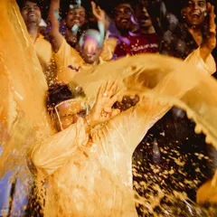 A high-energy moment from the groom's Haldi. Friends and family splash him with turmeric water, and we freeze the action to capture the joyful chaos.