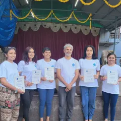 A proud moment for our graduates. Here, a group of newly certified teachers stands with their instructor, holding their RYT 200 certificates. This moment represents weeks of hard work, dedication, and profound learning.