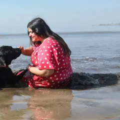 A shared moment of peace and connection amidst the gentle waves. This photograph captures the quiet bond between Rucha and her black Labrador, Murphy, during one of our 'joy of splashes' beach sessions.