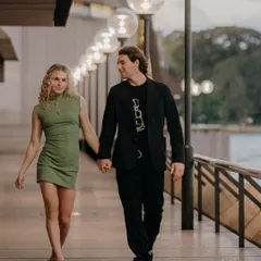 A simple, romantic shot of the couple walking hand-in-hand along a promenade in Sydney. The warm lighting and their connected gaze make for a timeless and natural portrait.