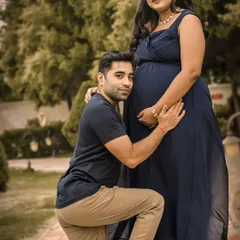 An outdoor setting is perfect for capturing the joy and anticipation between partners. Here, a dad-to-be shares a sweet moment with the baby bump, surrounded by the natural beauty of a garden.