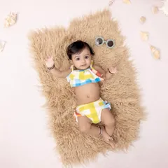 Beach baby vibes for this little one's photoshoot. Dressed in a colorful two-piece, she's ready for some sun and sand on our faux fur rug, surrounded by seashells.