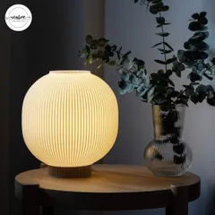 This spherical, ribbed table lamp provides a gentle, diffused glow. It's an excellent choice for creating a cozy and inviting atmosphere on tables in a cafe or as accent lighting in a salon's reception.