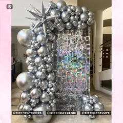 A pure chrome and silver balloon arch against a silver shimmer wall. This monochromatic design is incredibly chic and modern, perfect for a stylish celebration.