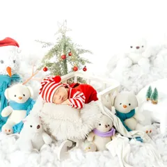 A winter wonderland for a newborn. This little one is dressed in a festive red and white striped outfit, sleeping among snowmen and polar bears.