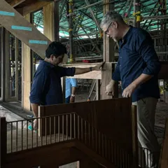 We use a combination of physical models and on-site discussions to refine our designs. Here, we are reviewing the staircase model with the carpentry team, ensuring the final construction will match the design intent perfectly.