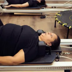 This shot captures a moment of rest and reset between exercises on the reformer. Proper alignment is key even during transitions to ensure a safe and effective workout.