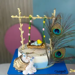 We love bringing festive themes to life with our edible art. This handcrafted Janmashtami cake setup, with its intricate details like the golden swing and peacock feathers, is a sweet offering designed to add a divine touch to your pooja or celebration.