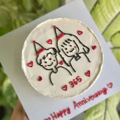 An overhead shot of the "365 days" cake, showing the full design and the "Happy Anniversary" message written on the cake board.