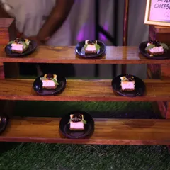 Bite-sized blueberry cheesecakes elegantly presented on individual black plates. This dessert is a perfect single-serving treat for weddings, corporate events, or any upscale gathering.