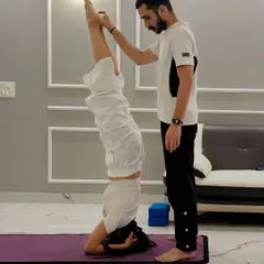 Here, I'm providing support for a student's Sirsasana (Headstand). My guidance helps with balance and alignment, making inversions accessible and safe even if you are a beginner.