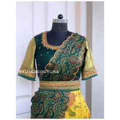 A traditional Kalamkari Langa Voni set. This outfit features a dark green blouse with gold sleeves, a yellow lehenga skirt, and a beautiful Kalamkari print dupatta, all tied together with a matching embroidered belt.