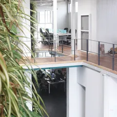 A view through the central void in our office, looking from one level to another. This open, double-height space promotes visual connectivity and a sense of community among our team.