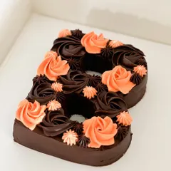 Sweeten up your feed with this delicious monogram chocolate cake. This "B" is decorated with rich chocolate and beautiful orange-colored rosettes, and it's available in a vegan version too.