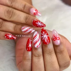 A classic Christmas set on soft gel extensions. This design features candy cane stripes, snowflakes, and cute red bows.