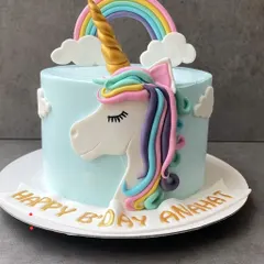 A magical unicorn cake. This popular design features a golden horn, rainbow-colored mane, and sleepy eyes, perfect for a whimsical birthday party.