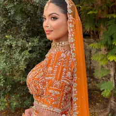 Every feature enhanced, every detail perfected. This bride in a vibrant orange lehenga is the perfect balance of soft glam and timeless elegance.