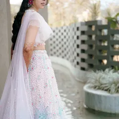 A beautiful three-quarter shot of the bride in her stunning pastel lehenga. This portrait captures her elegance and the intricate details of her outfit.