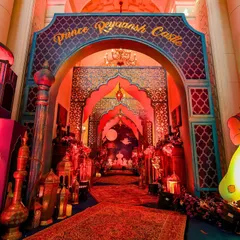 The grand entrance to "Prince Reyaansh's Castle," designed with layered arches, character cutouts, and a carpeted walkway to welcome the little guests.