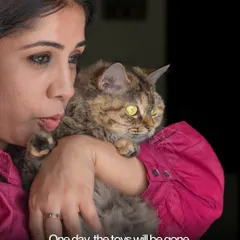 A woman holding her cat, a poignant reminder that one day, the toys will be gone, but the memories and photos will remain.