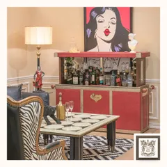 Make a bold statement with the Mamba automated bar. Its vibrant red leather finish and sleek design conceal a complete bar setup, perfect for modern and eclectic interiors.