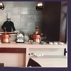 A chef at an indoor live station, ensuring all hygiene standards are met while preparing fresh food for guests. This setup is perfect for office lunch catering and seminars.