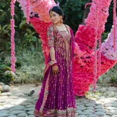 A bride in a vibrant magenta Anarkali, her effortless radiance shining through in a beautiful garden setting at Taj Corbett.