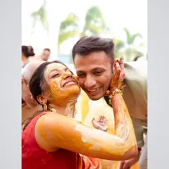 A candid moment of pure affection during the Haldi ceremony. The bride, covered in turmeric, pulls the groom in for a hug, showcasing the fun and love-filled atmosphere.